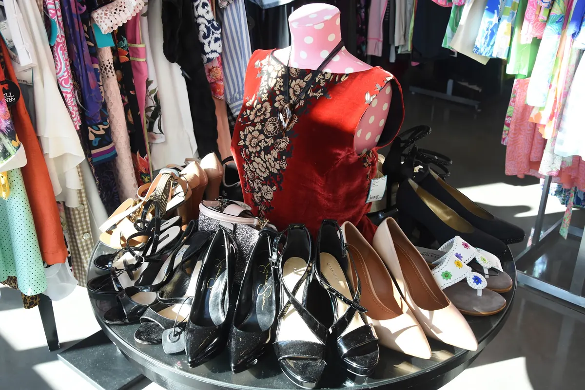 Heels arranged around a mannequin in a red top